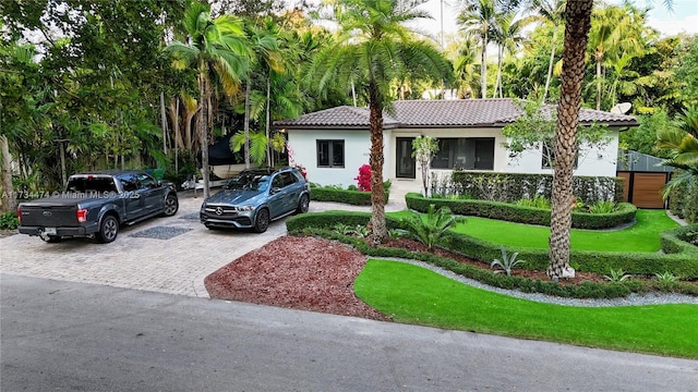 view of front of property with a tile roof, stucco siding, and driveway