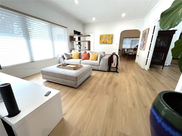 living area featuring ornamental molding, arched walkways, light wood-style floors, and recessed lighting