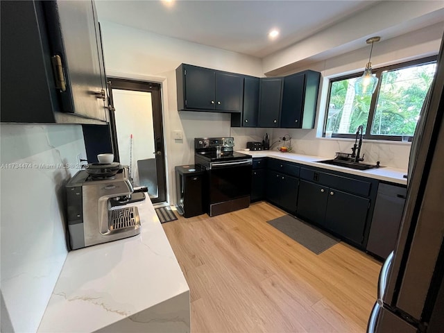 kitchen with pendant lighting, sink, fridge, black range with electric cooktop, and light wood-type flooring