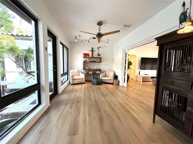 living area featuring ceiling fan and light hardwood / wood-style floors