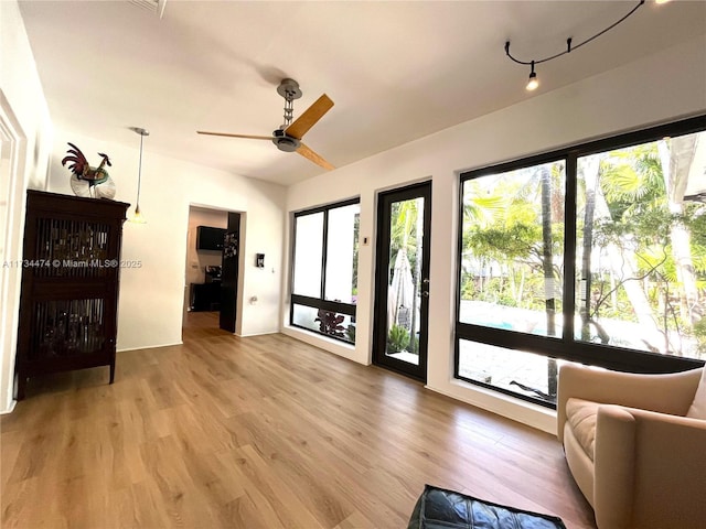 living area with a ceiling fan and light wood-type flooring