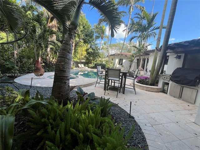 view of patio / terrace with an outdoor pool, area for grilling, and outdoor dining space