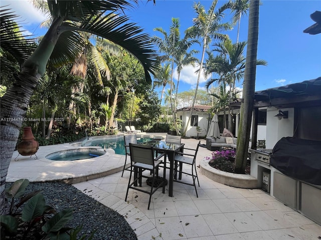 view of patio / terrace featuring a swimming pool with hot tub and an outdoor kitchen