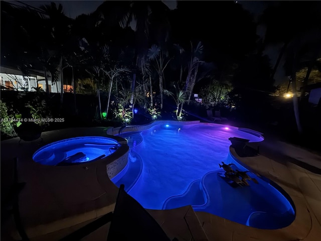 pool at night with an in ground hot tub