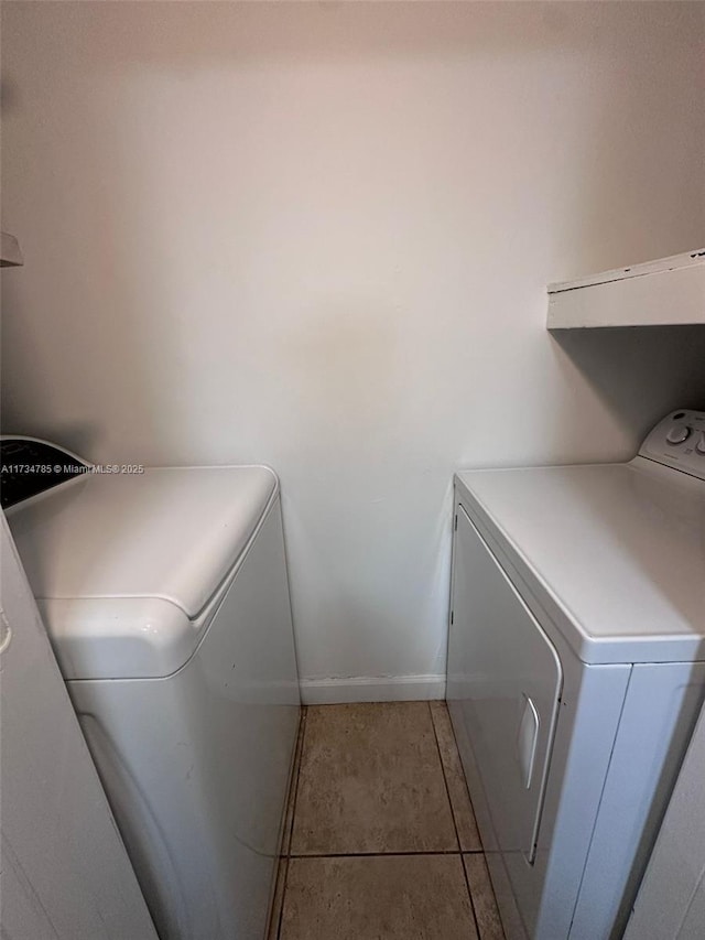 clothes washing area with separate washer and dryer and tile patterned floors