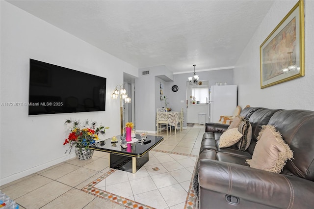 living room with light tile patterned floors, a notable chandelier, and a textured ceiling