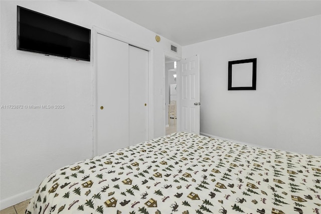 tiled bedroom with a closet