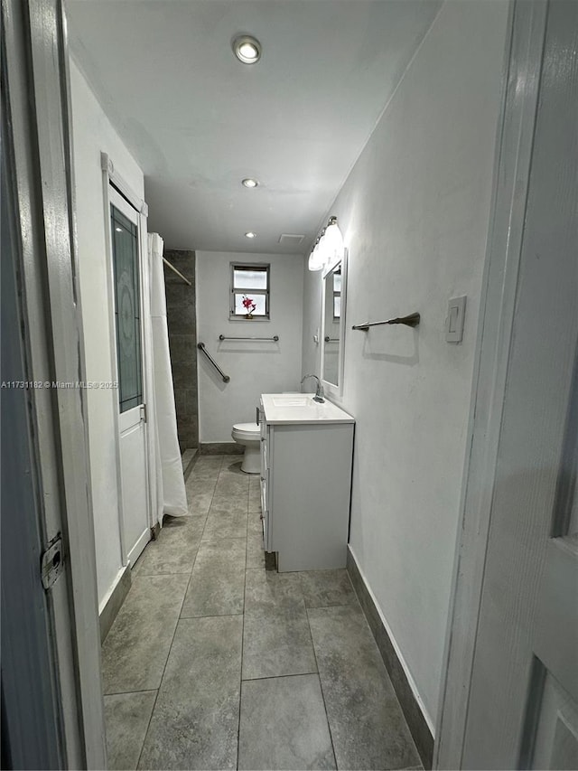 bathroom with vanity, a shower, and toilet