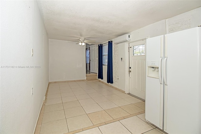 tiled foyer entrance with ceiling fan, a textured ceiling, and an AC wall unit