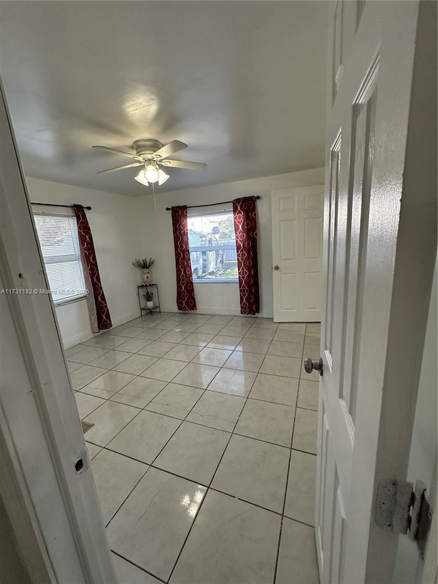 tiled spare room with ceiling fan