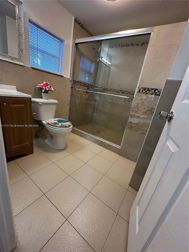 bathroom featuring vanity, toilet, a shower with shower door, and tile patterned flooring