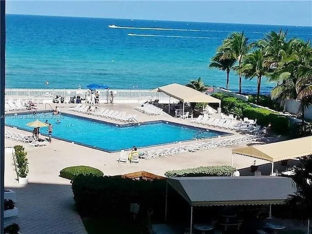 view of pool featuring a patio area and a water view