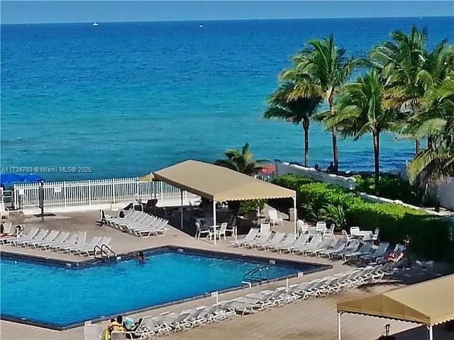 view of swimming pool with a water view and a patio