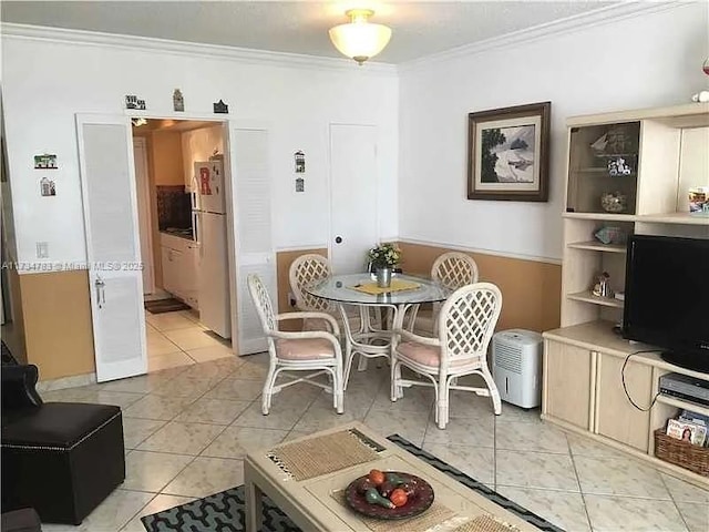 tiled dining area featuring crown molding