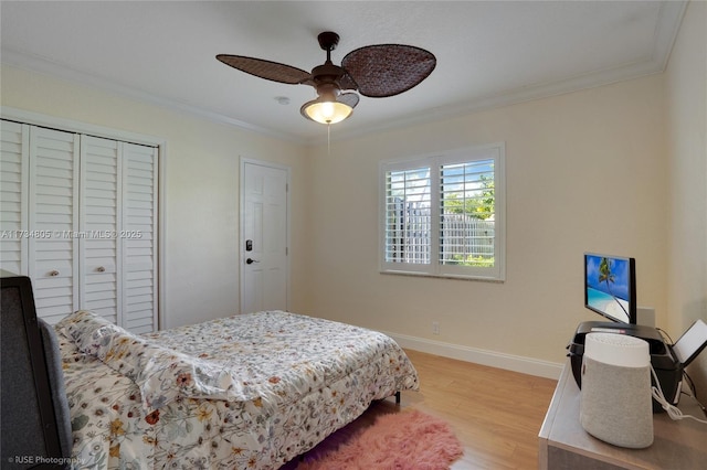 bedroom with light hardwood / wood-style flooring, ornamental molding, and ceiling fan