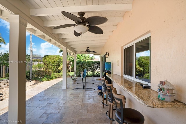 view of patio featuring ceiling fan and exterior bar