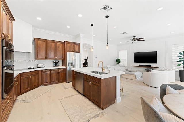 kitchen with visible vents, stainless steel appliances, a sink, and open floor plan