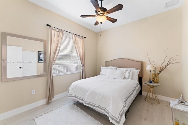 bedroom featuring ceiling fan, wood finished floors, visible vents, and baseboards