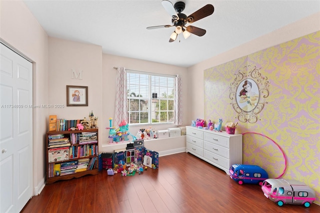 playroom with ceiling fan, baseboards, and wood finished floors