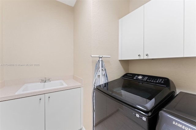 washroom featuring cabinet space, a sink, and separate washer and dryer