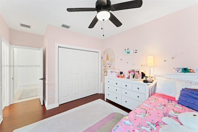 bedroom featuring a ceiling fan, a closet, visible vents, and wood finished floors