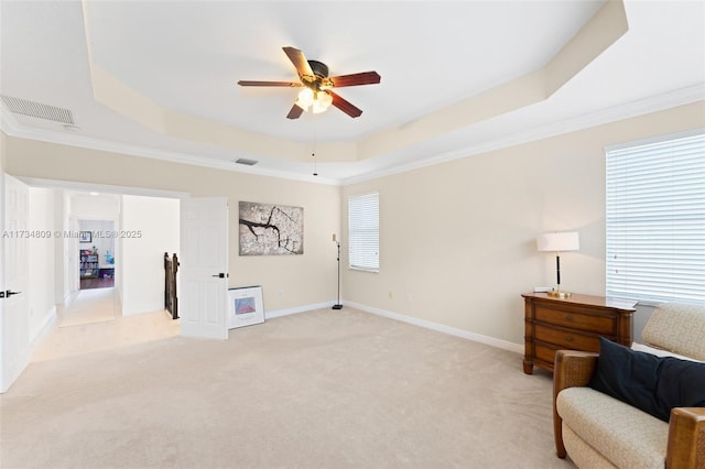 living area featuring visible vents, baseboards, light colored carpet, a tray ceiling, and crown molding