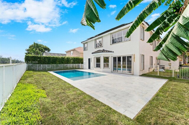 rear view of house featuring a patio area, a fenced backyard, and a lawn