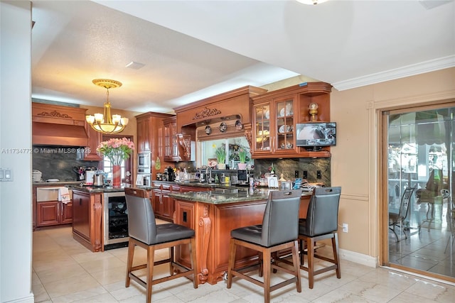 kitchen with a breakfast bar area, decorative light fixtures, dark stone countertops, beverage cooler, and decorative backsplash