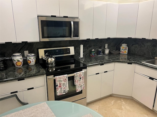 kitchen featuring stainless steel appliances, white cabinetry, light tile patterned flooring, and decorative backsplash