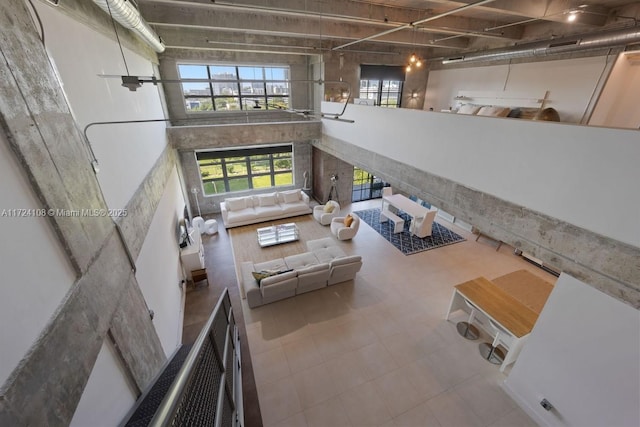 unfurnished living room with a towering ceiling and a healthy amount of sunlight