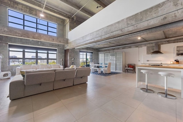 tiled living room featuring a towering ceiling