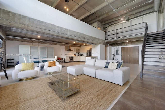 living room featuring concrete floors and a high ceiling