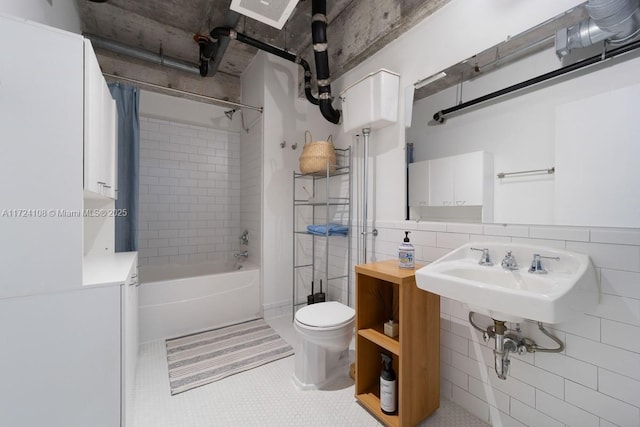 bathroom featuring tile patterned flooring, toilet, tile walls, and shower / bath combo with shower curtain