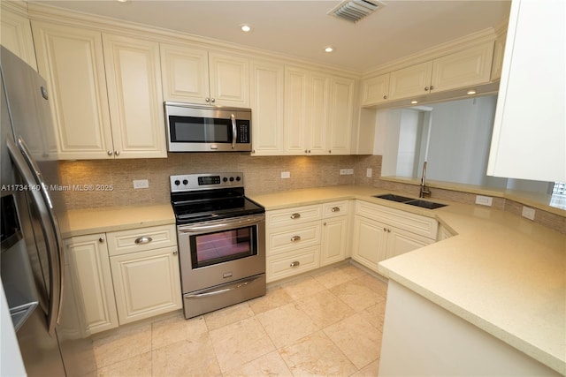 kitchen featuring appliances with stainless steel finishes, sink, and backsplash