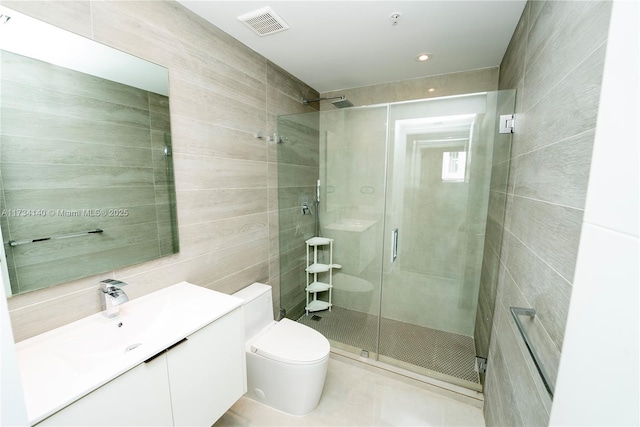 bathroom with tile walls, vanity, toilet, and walk in shower