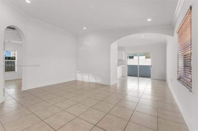 tiled empty room featuring ornamental molding and a healthy amount of sunlight