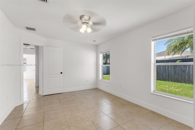 unfurnished room with light tile patterned floors, plenty of natural light, and ceiling fan