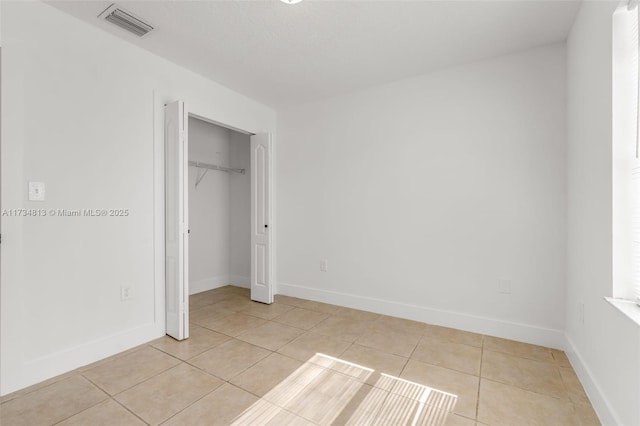 unfurnished bedroom with light tile patterned floors and a closet