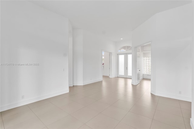 empty room with light tile patterned floors and french doors