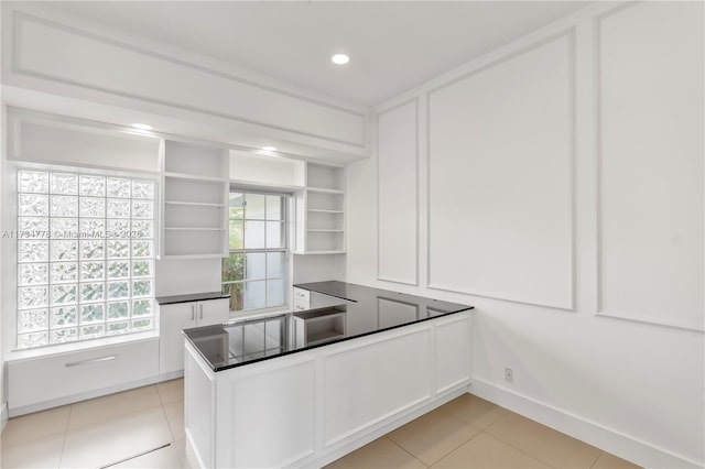 kitchen with white cabinetry, light tile patterned floors, built in shelves, and kitchen peninsula