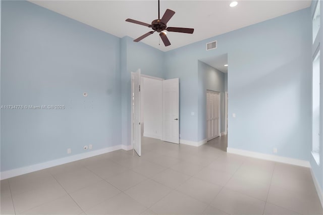 empty room featuring ceiling fan and light tile patterned floors