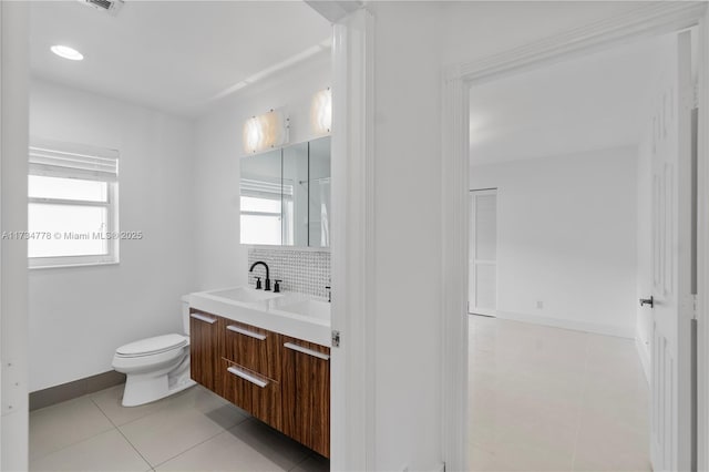 bathroom with plenty of natural light, backsplash, tile patterned floors, and toilet