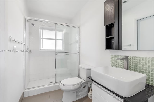 bathroom with tile patterned floors, toilet, a shower with shower door, and vanity