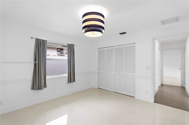 unfurnished bedroom featuring tile patterned flooring and a closet