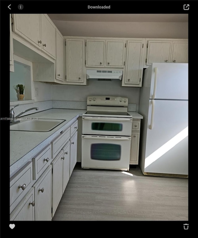 kitchen with sink, white appliances, and light hardwood / wood-style flooring