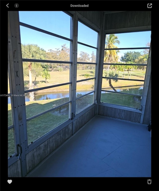 unfurnished sunroom featuring a water view