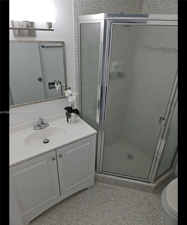 bathroom with walk in shower, tile patterned floors, toilet, and vanity