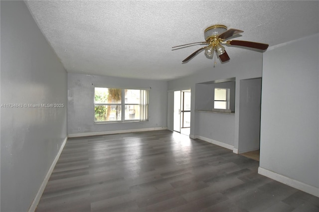 empty room with ceiling fan, dark hardwood / wood-style floors, and a textured ceiling