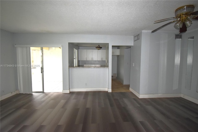 unfurnished living room with dark wood-type flooring, ceiling fan, and a textured ceiling