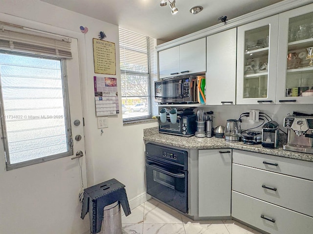 kitchen featuring light stone countertops and oven